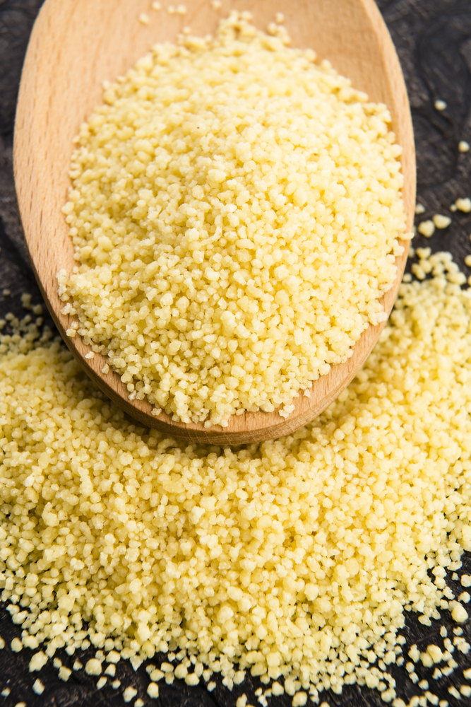 Couscous roh in einem Holzlöffel